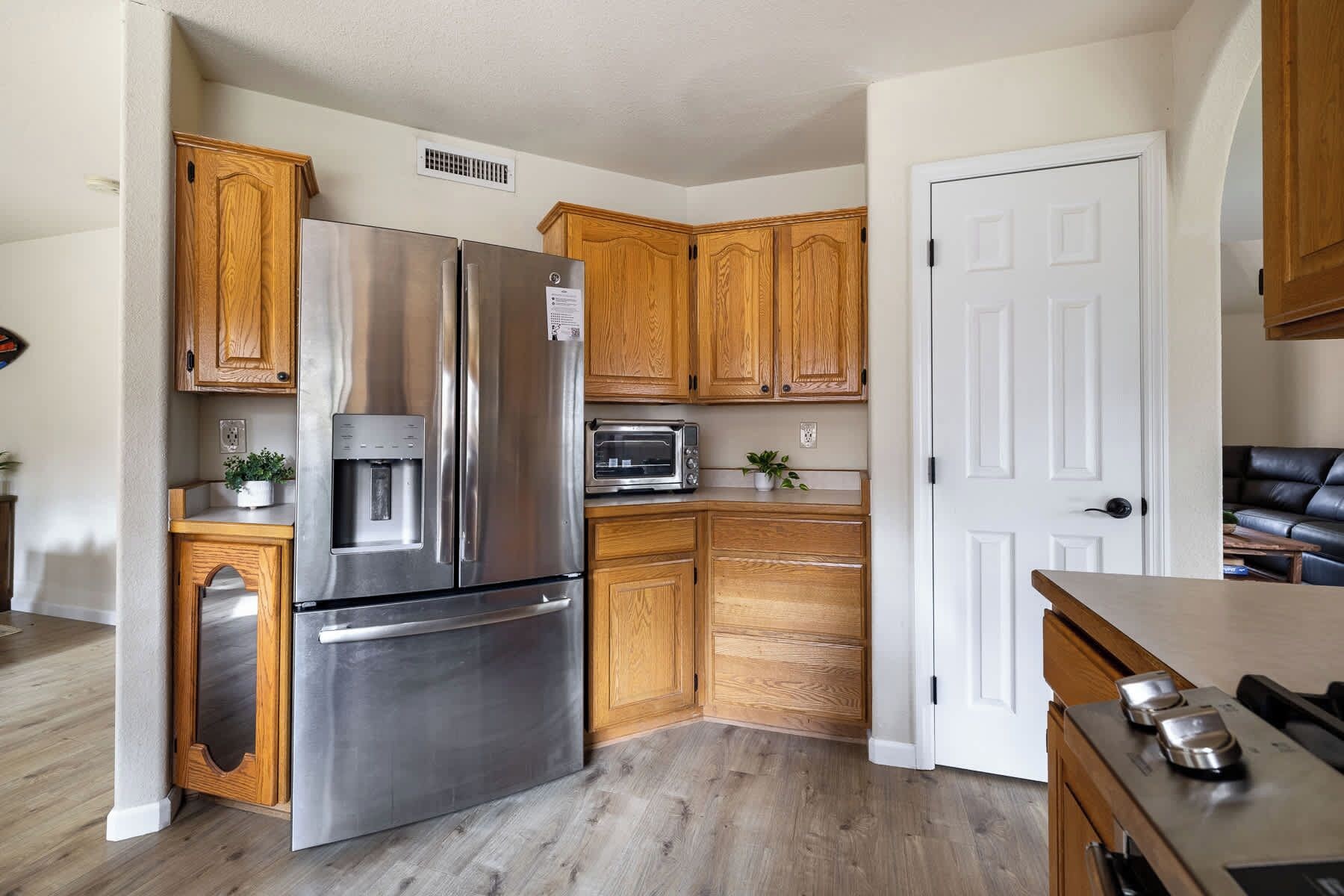 A kitchen with wooden cabinets, a stainless steel refrigerator, a microwave, and a water dispenser.