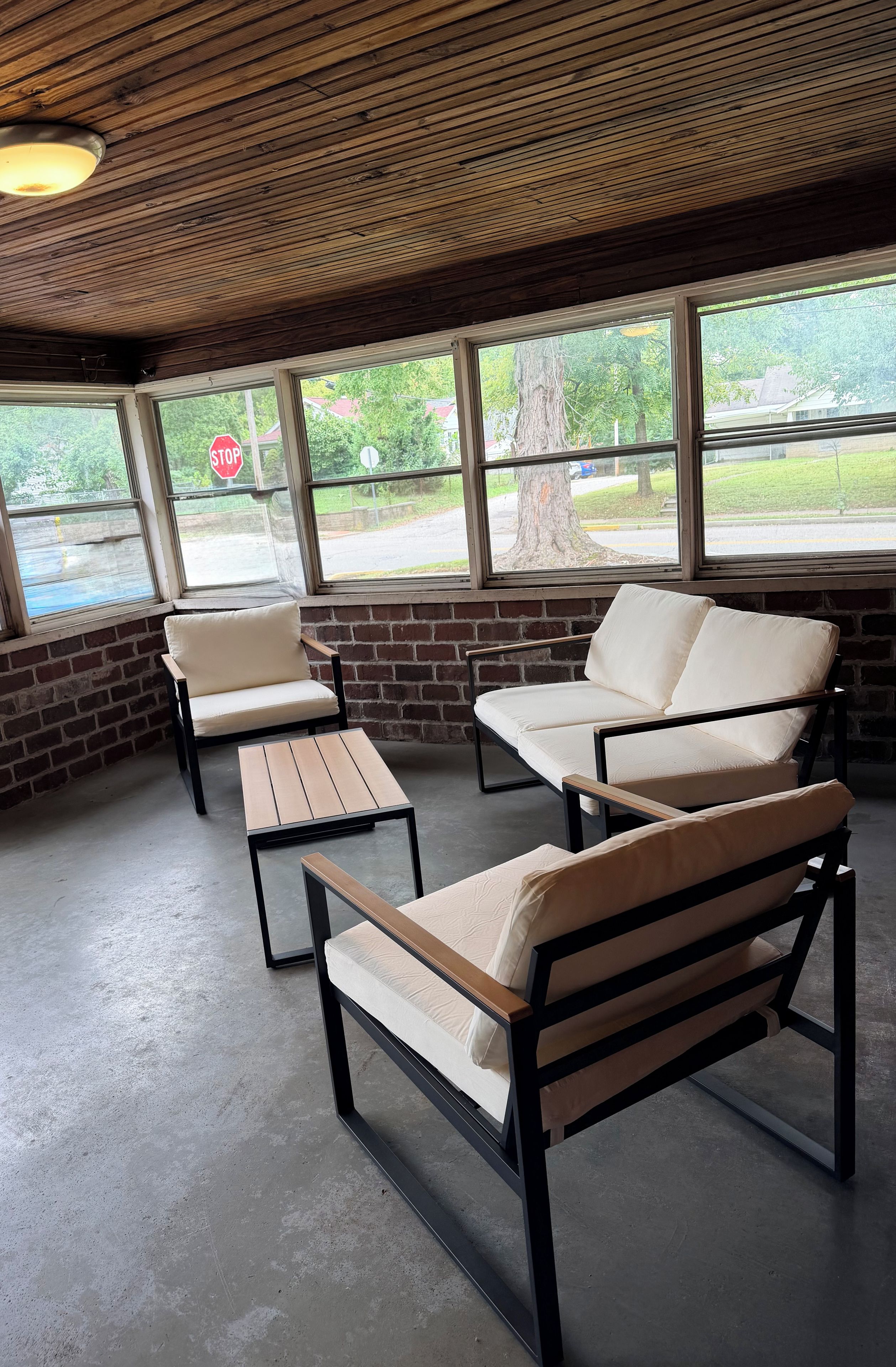 A seating area with a brick wall and large windows overlooking a street.