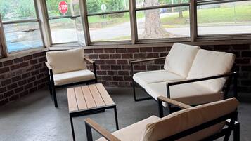 A seating area with a brick wall and large windows overlooking a street.