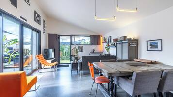 Een moderne keuken met een eethoek, grote ramen en uitzicht op de omgeving.