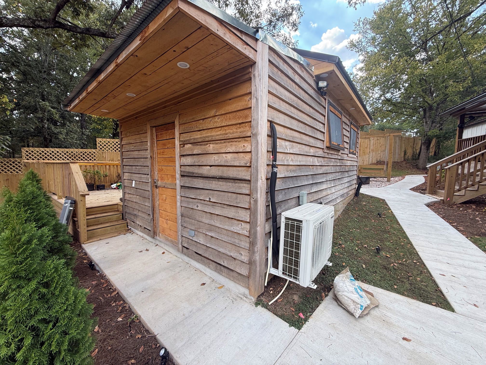 Eine Holzhütte mit Veranda, einer Tür und einer Klimaanlage.