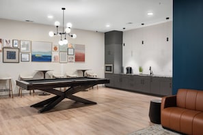 A modern living room with a pool table, a sofa, and a dining area. - Duck Island 1BR , Walk to Ohio City + Parking (Cleveland)