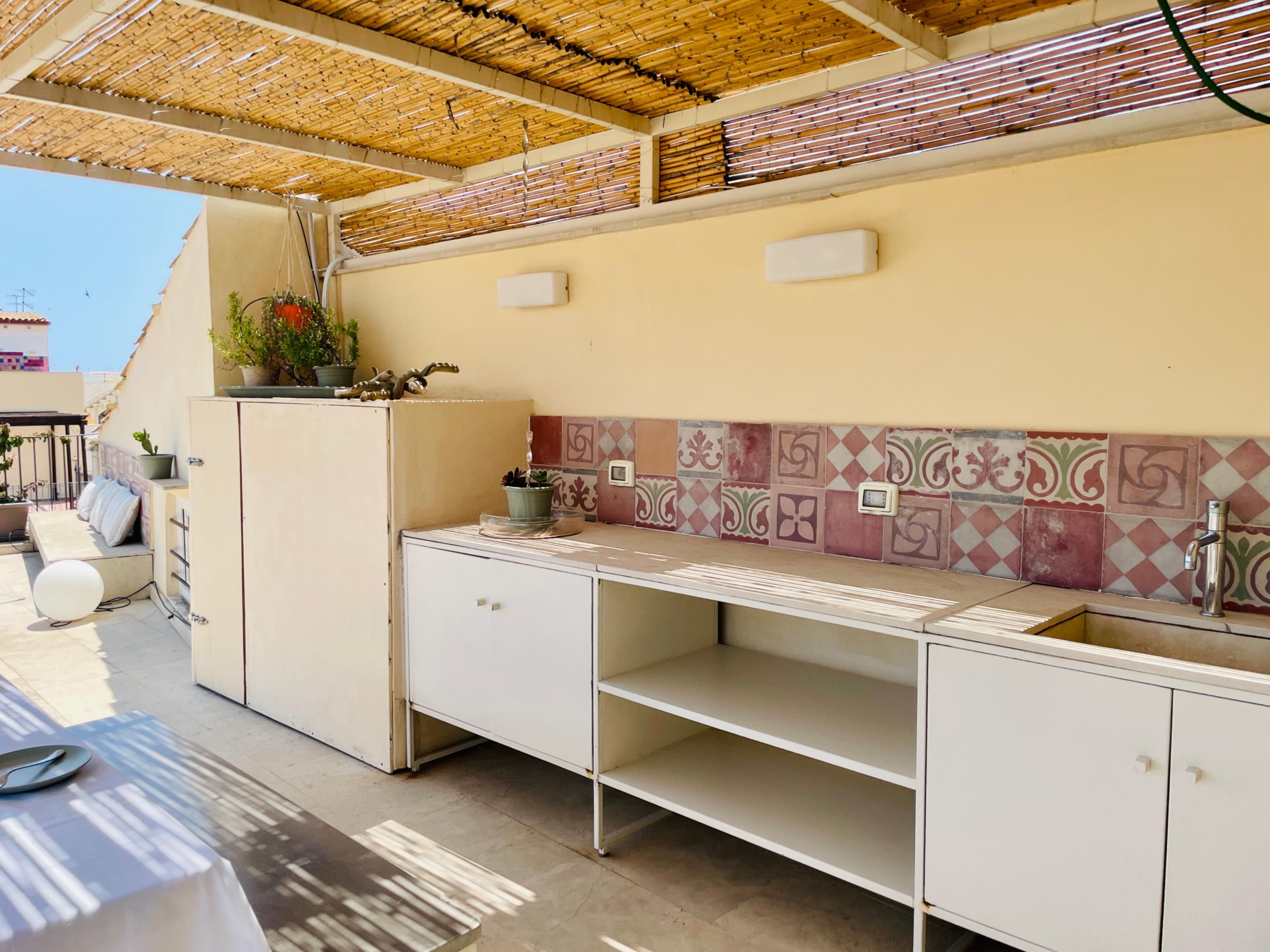 A kitchen with a tiled backsplash, a sink, and a countertop.