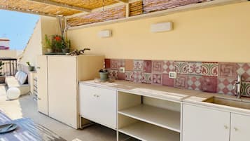 A kitchen with a tiled backsplash, a sink, and a countertop.