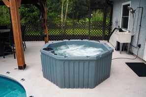 A hot tub with a wooden deck and a pool in the background. - West Melbourne/Palm Bay, R&R pool hot tub home, quiet, safe close to everything! (Palm Bay)