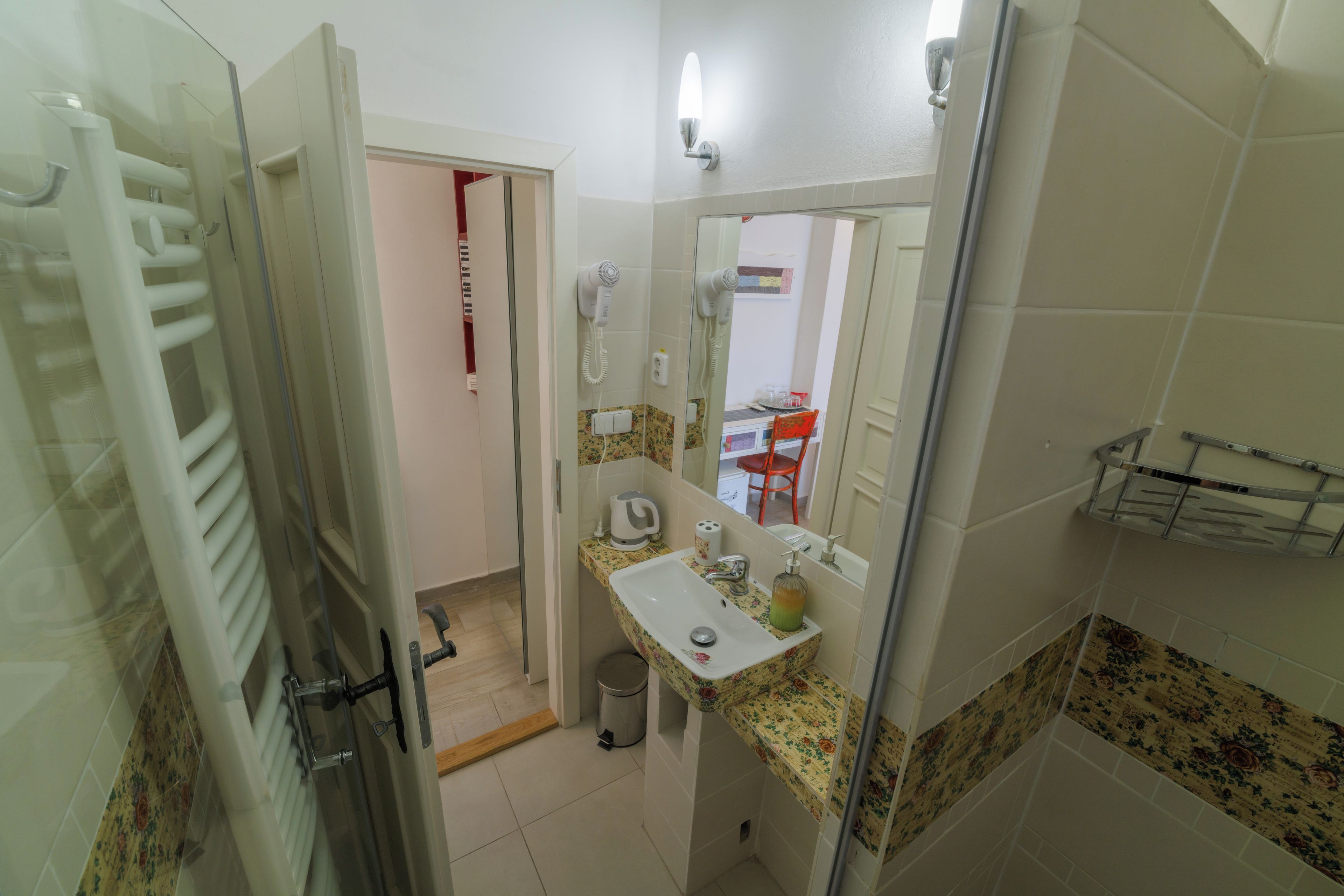A bathroom with a shower, a sink, and a hairdryer.