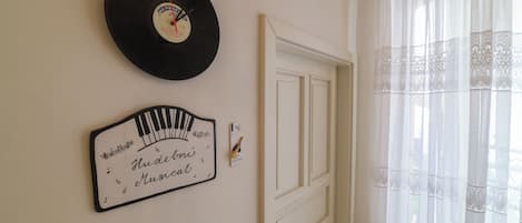 Una pared con un disco de vinilo, un letrero con forma de piano y una puerta.