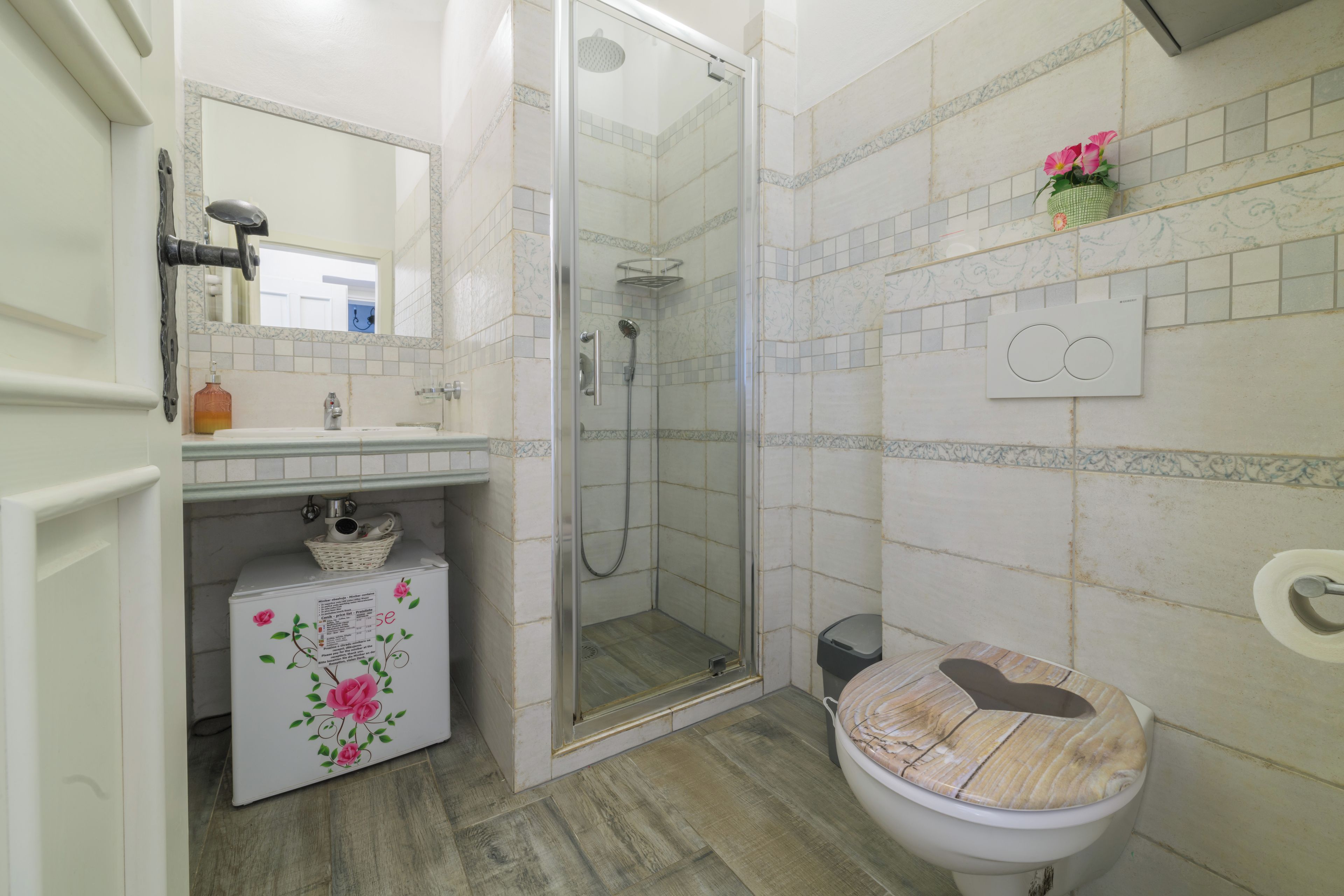 Un baño con ducha, inodoro, lavabo y espejo.