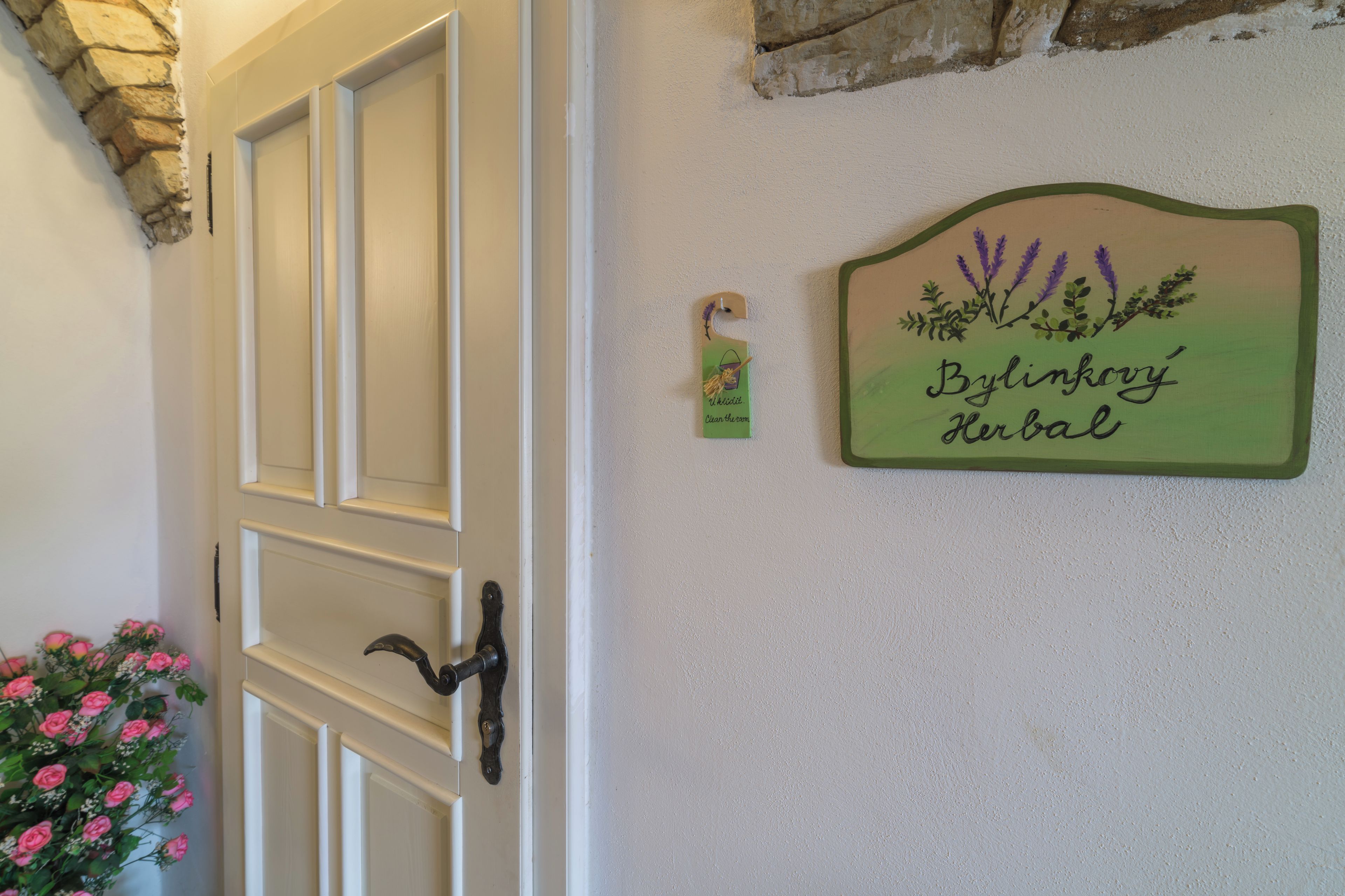 A door with a keyhole and a wall-mounted sign that reads 'Bylinkowy Herbal'.
