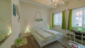 Un dormitorio con cama, mesitas de noche, escritorio y una silla.