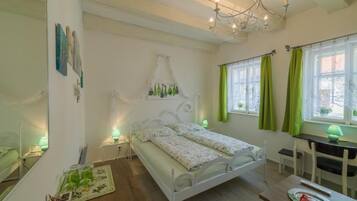 A bedroom with a bed, bedside tables, a desk, and a chair.