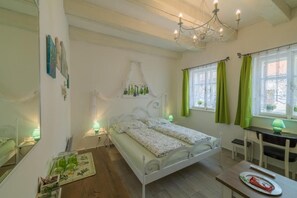 A bedroom with a bed, bedside tables, a desk, and a chair. - Penzion U Zámku Mělník (Mělník)
