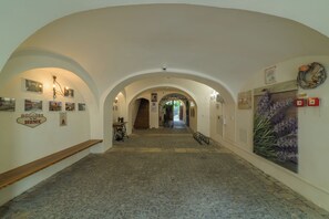 A hallway with arched ceilings, a staircase, and various wall decorations including a welcome sign and a total stop sign. - Penzion U Zámku Mělník (Mělník)