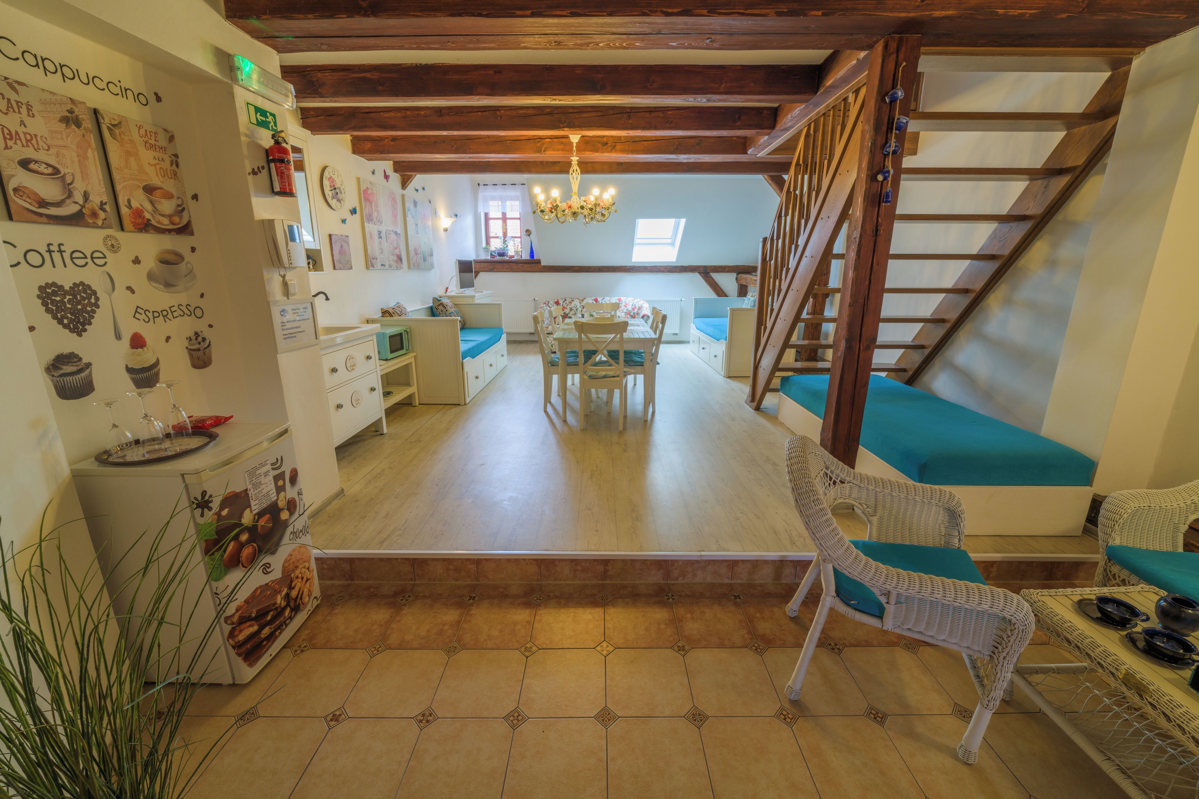 Un interior acogedor con una escalera de madera, un comedor y una cocina con cafetera.