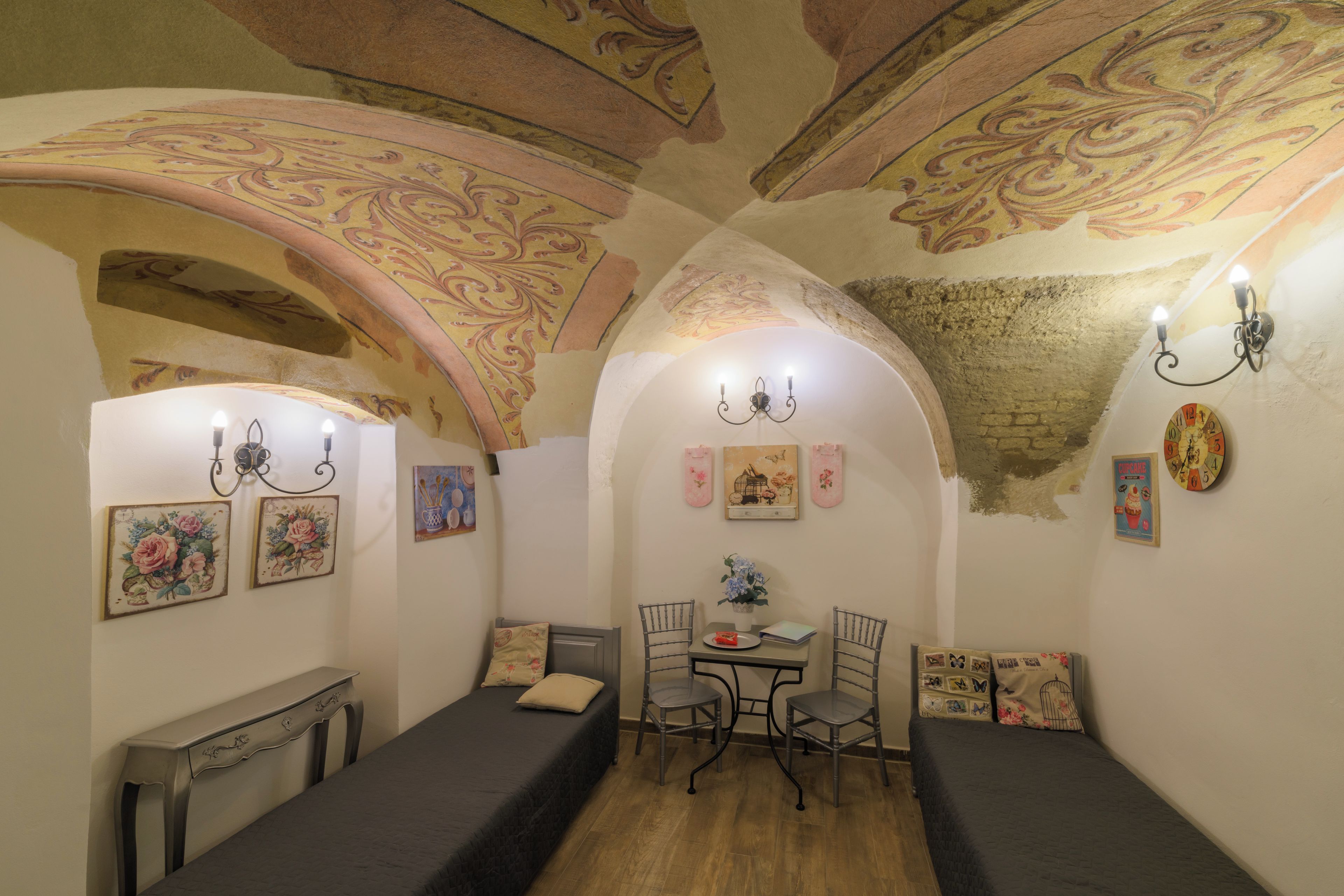 Una habitación acogedora con una cama, una mesa con sillas y un techo decorativo.