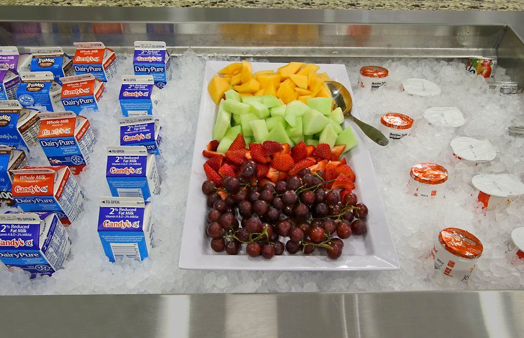En buffet med mejeriprodukter og frisk frugt på is.