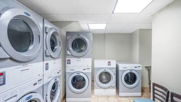 A laundry room with multiple stacked washing machines and dryers.