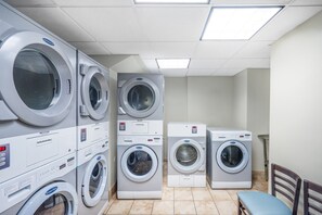 A laundry room with multiple stacked washing machines and dryers.