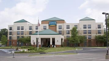 Um hotel Staybridge Suites com entrada central, vários andares e estacionamento.