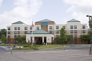A Staybridge Suites hotel with a central entrance, multiple floors, and a parking lot.
