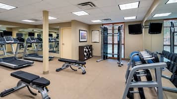 A gym with treadmills, a bench press, and weightlifting equipment.