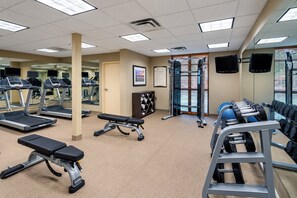 A gym with treadmills, a bench press, and weightlifting equipment.