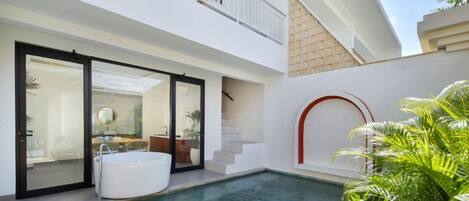 A modern house with a swimming pool, a hot tub, and a balcony.