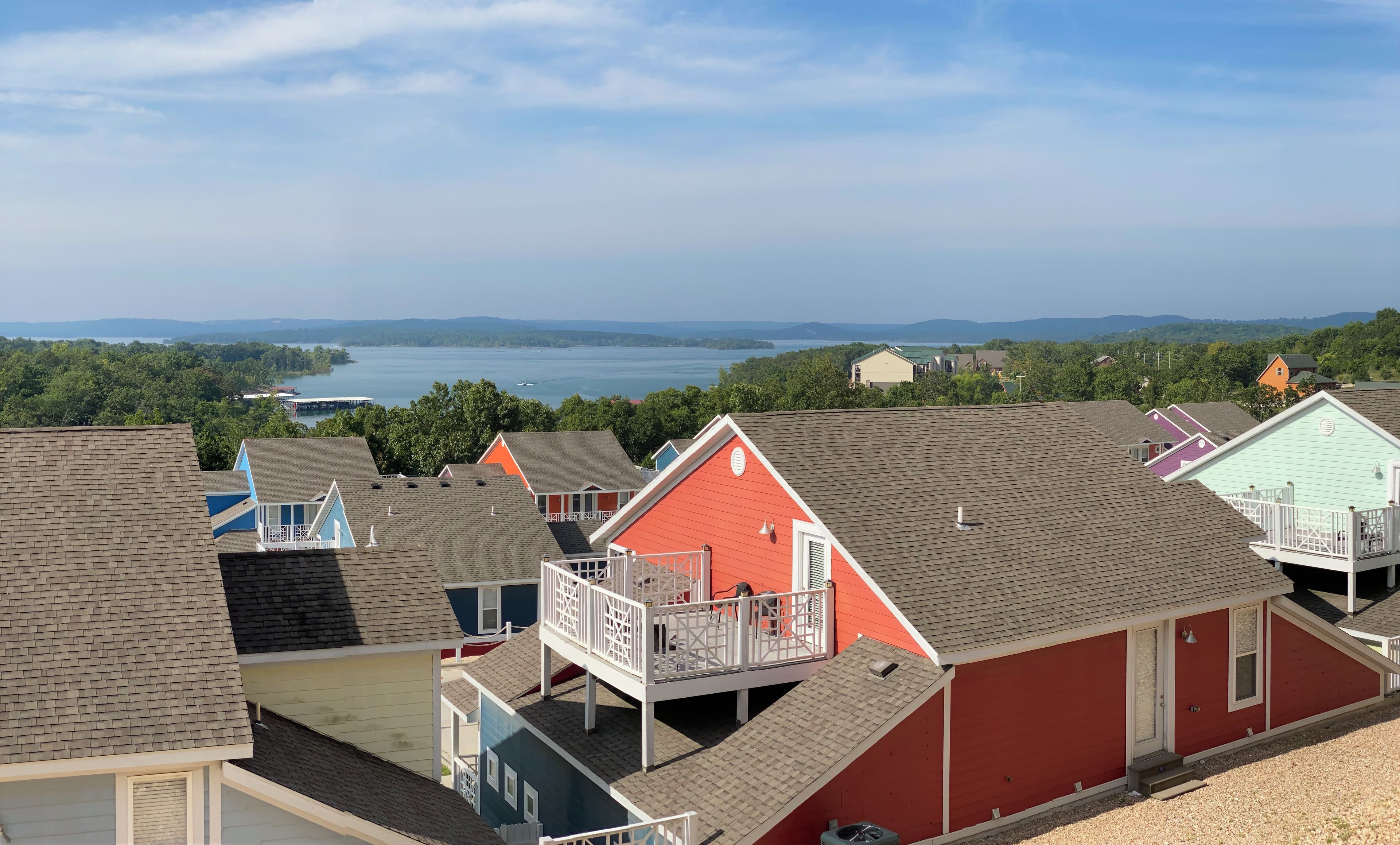 A residential area with houses, a dock, and a lake in the background.