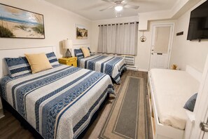 A bedroom with two beds, a ceiling fan, a TV, and a painting on the wall. - Downtown Ocean City Condo with 2 Full Baths, Pool & Parking (Ocean City)