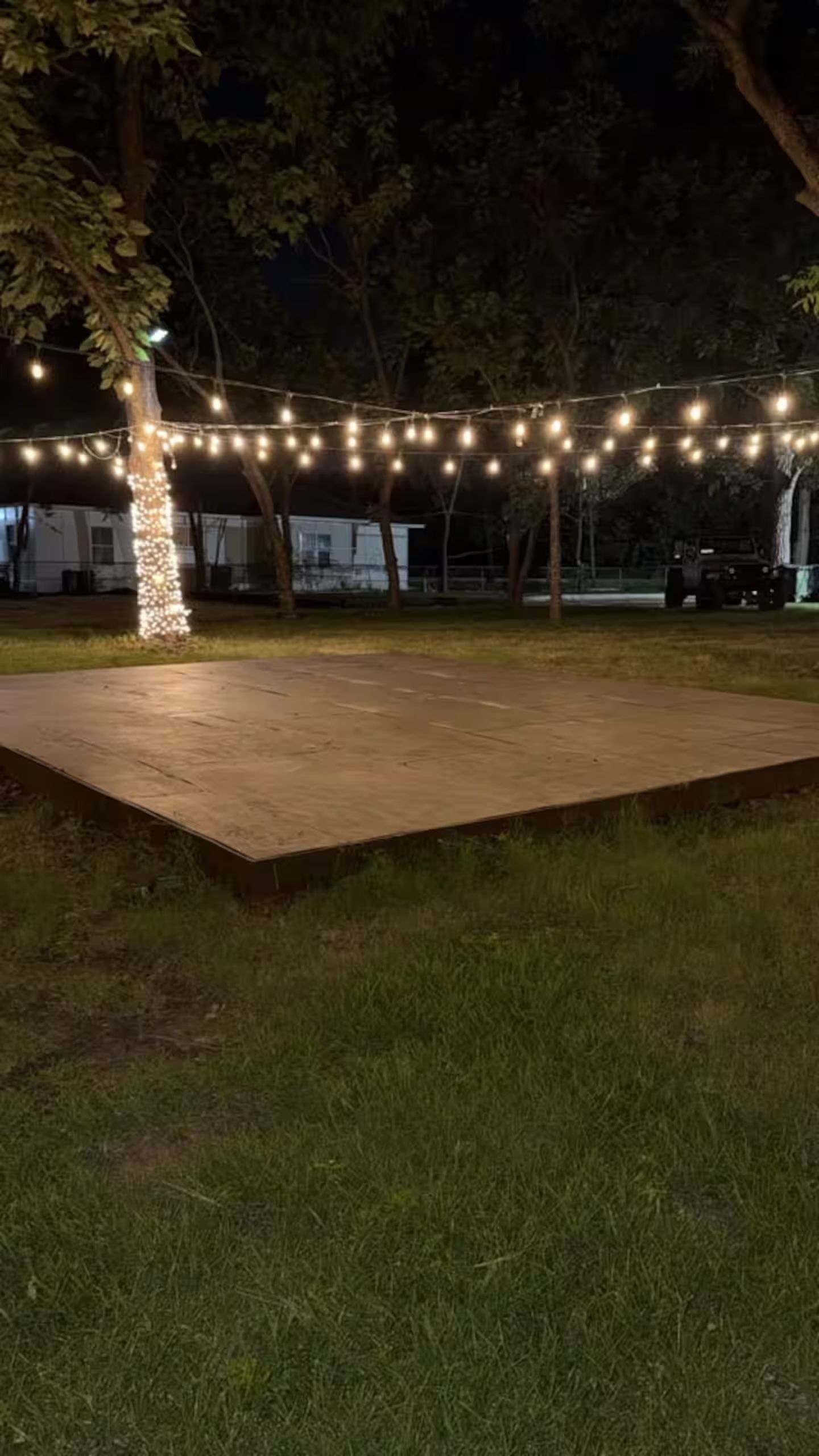 An outdoor area with a paved platform and string lights.