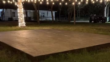 An outdoor area with a paved platform and string lights.