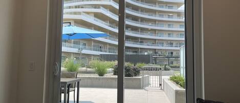 A modern building with multiple balconies and a patio area with outdoor furniture.