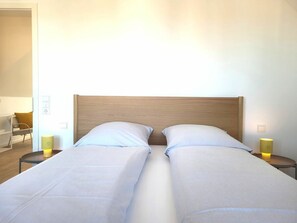 A double bed with a wooden headboard in a hotel room. - Heiligenhafenbude 2 (Heiligenhafen)