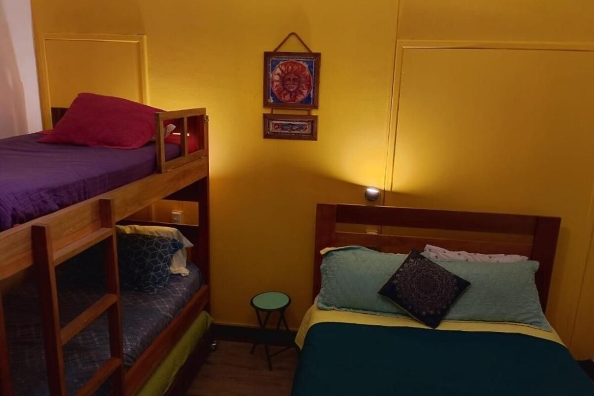 Una camera del dormitorio con letti a castello, un tavolino rotondo e una mensola a parete.