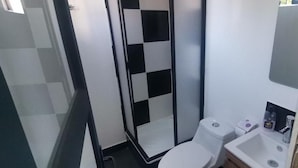 Un bany amb dutxa, vàter i rentapeus.