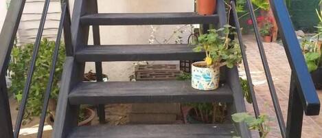 A black metal staircase with potted plants on each step.