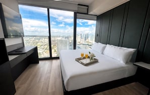 A modern hotel room with a large bed, a bedside table, a TV, and a city view. - Glam Miami Nightlife - Resort Pool - Downtown (Miami)
