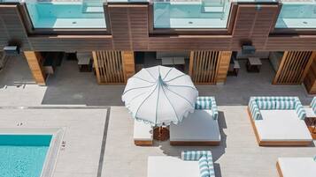 Un espace piscine aménagé sur le toit, avec des chaises longues et un parasol.