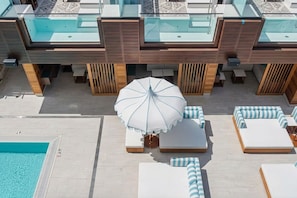 A rooftop pool area with lounge chairs and an umbrella. - Glam Miami Nightlife - Resort Pool - Downtown (Miami)
