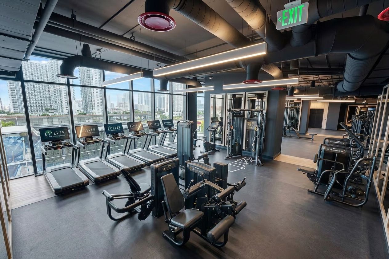 Une salle de sport équipée de tapis de course, d’appareils de musculation et d’autres équipements d’exercice.