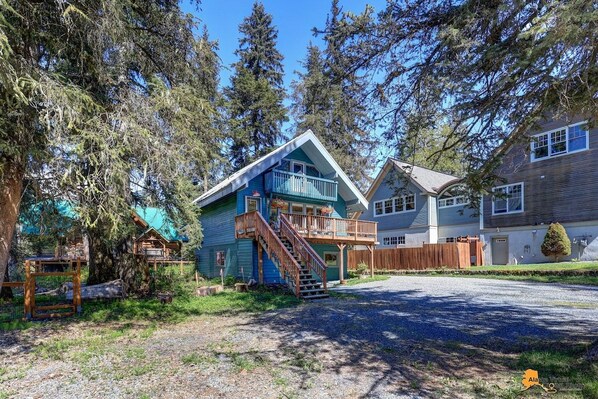 A residential property with a two-story house, a covered porch, and a wooden deck.