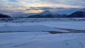 Eine verschneite Landschaft mit einem Berg im Hintergrund.