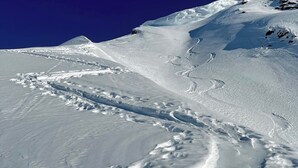 Ein mit Schnee bedeckter Berg unter blauem Himmel.