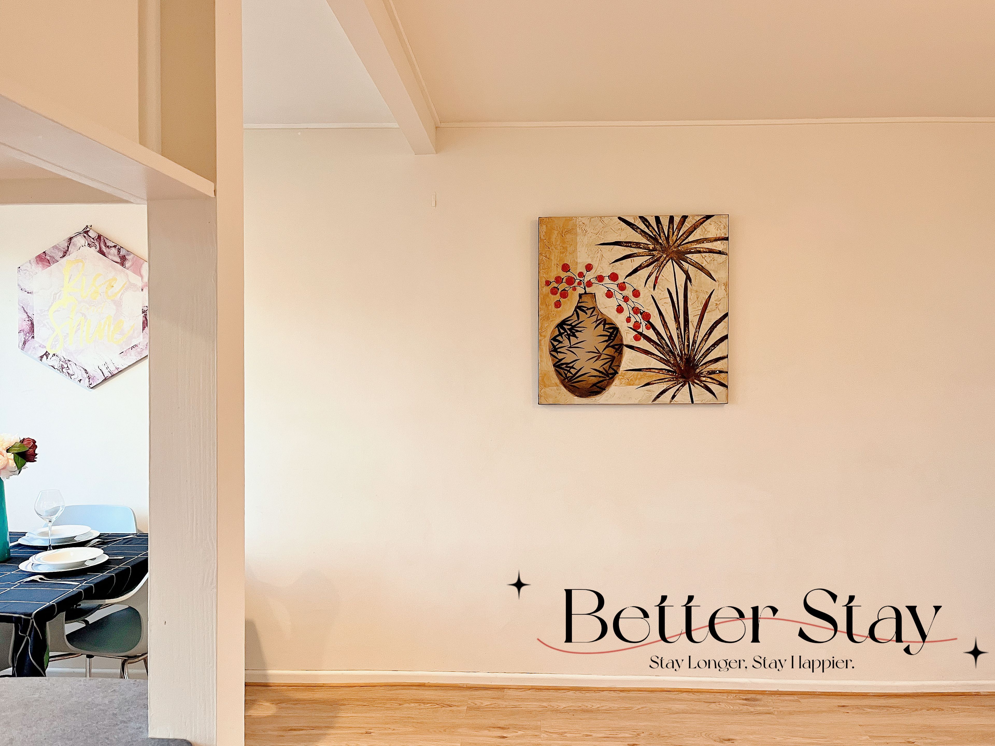 A room with a dining area, a wall with a motivational quote, and a decorative piece.