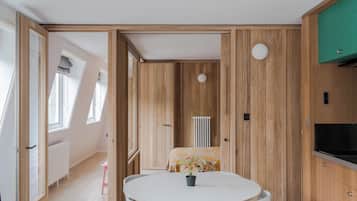 Une pièce avec une table ronde, un radiateur et un lambris en bois.