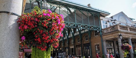 Et livligt marked med en iøjnefaldende blomsterudsmykning og traditionel arkitektur.