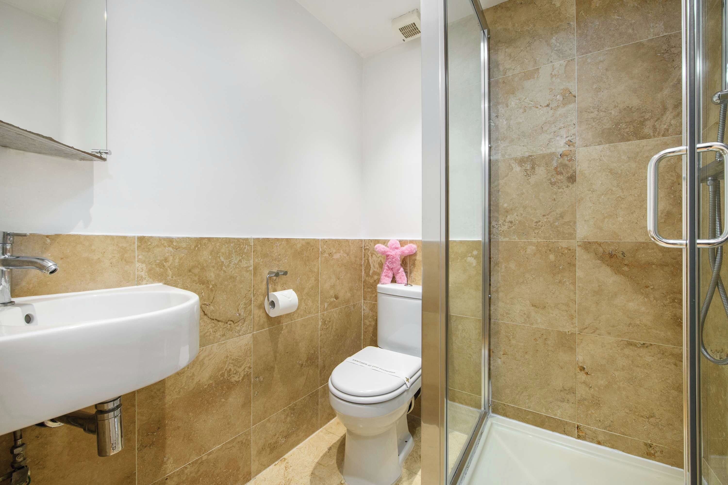 A bathroom with a sink, toilet, and shower.