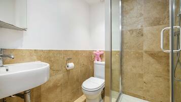 A bathroom with a sink, toilet, and shower.