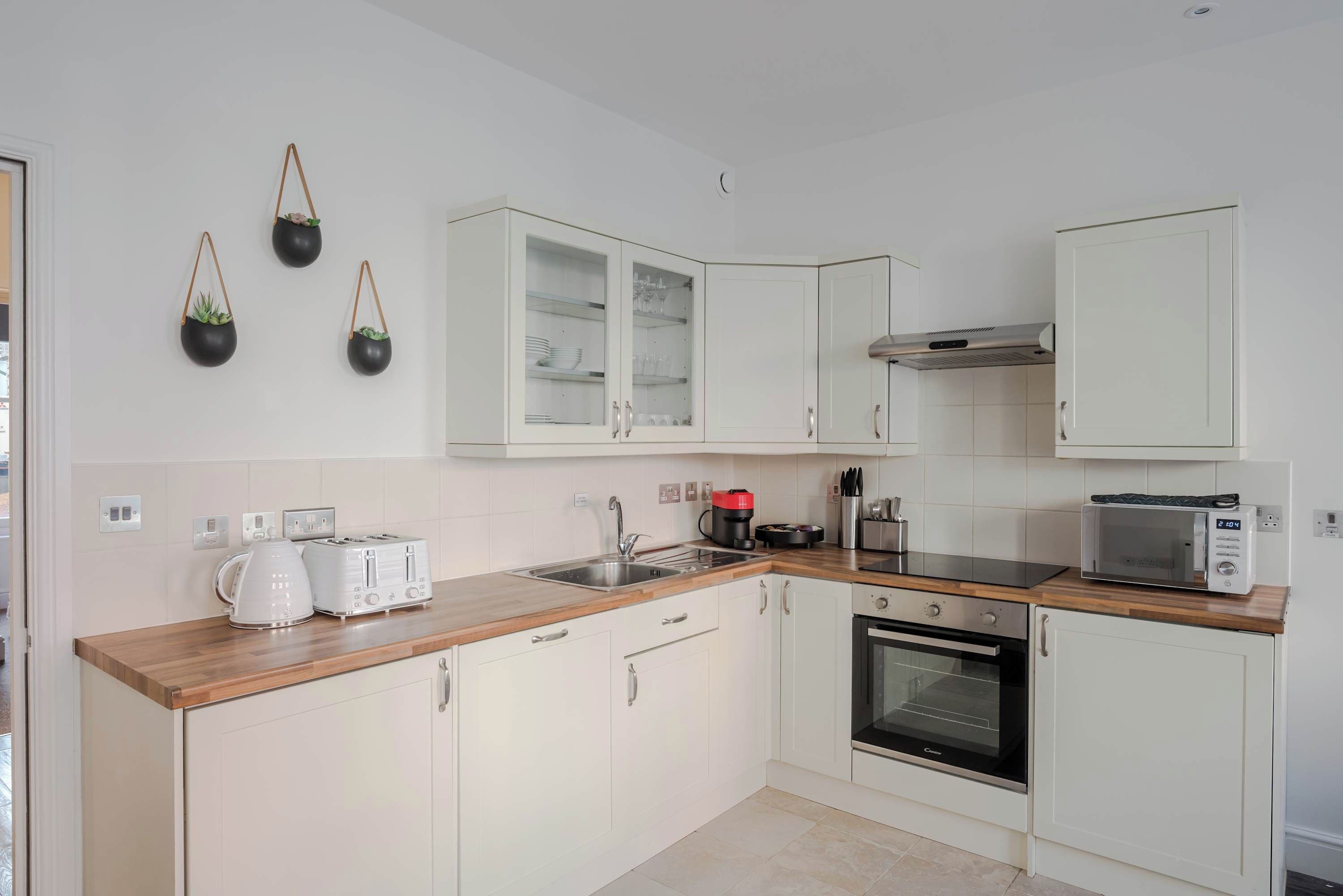 A kitchen with white cabinets, a microwave, a toaster, and a coffee maker.