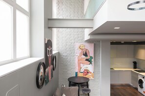 Eine moderne Küche mit integriertem Waschmaschine, ein Essbereich mit rundem Tisch und Stühlen sowie ein großes Fenster für natürliches Licht.